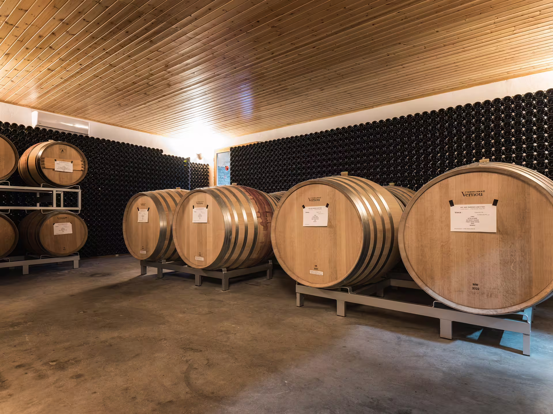 Barrel aging room with stacked bottles at an organic winery near Pavia, part of Oltrepò Pavese tasting tour