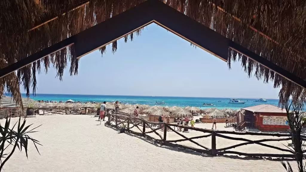 Beach huts and umbrellas overlooking the Red Sea at Paradise Island, relaxing day trip with boat transfer