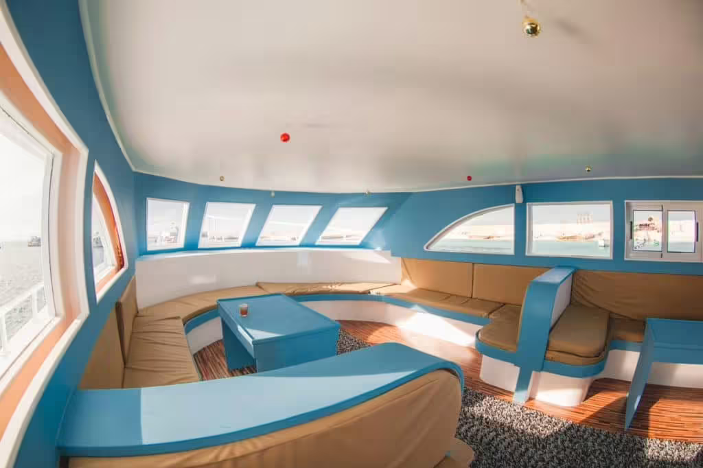 Spacious boat lounge with panoramic windows for Day on the Paradise Island cruise, relaxing sea views