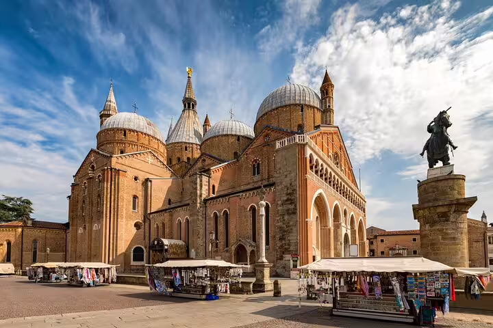 Guided walking tour guests exploring Padua’s Basilica of Saint Anthony and lively market stalls in the historic city center
