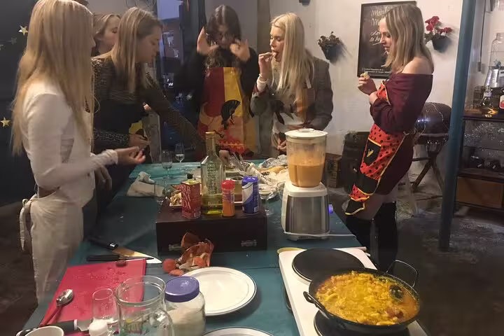Participants gathered around a table during a lively paella and salmorejo cooking class in Córdoba.
