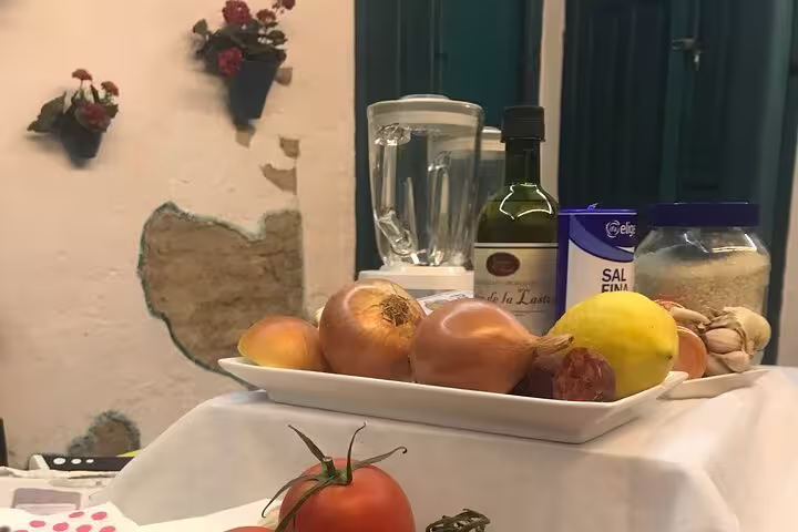 Ingredients for Paella and Salmorejo class in Córdoba featuring onions, olive oil, and fresh produce.