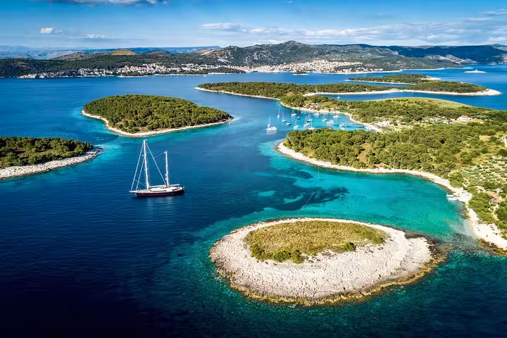 Drone view of Pakleni Islands lagoons with sailboat and crystal-clear Adriatic water on Hvar Vis tour