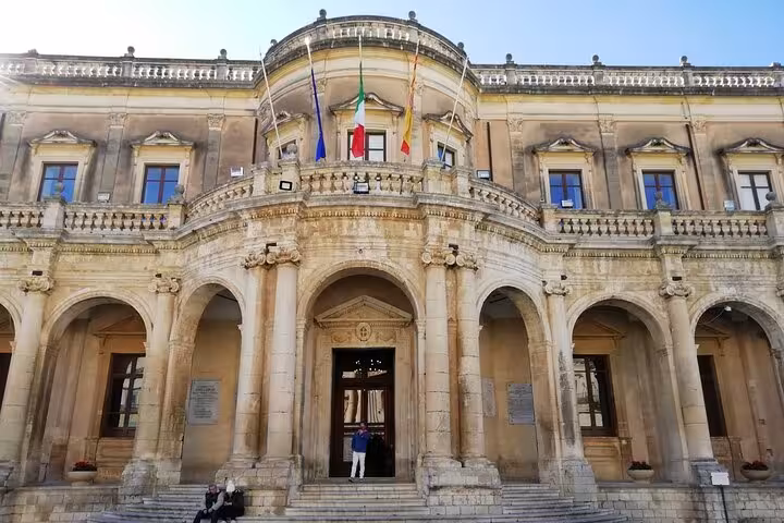 Admire the neoclassical architecture of Palazzo Ducezio in Noto, a highlight of Sicily’s baroque heritage.