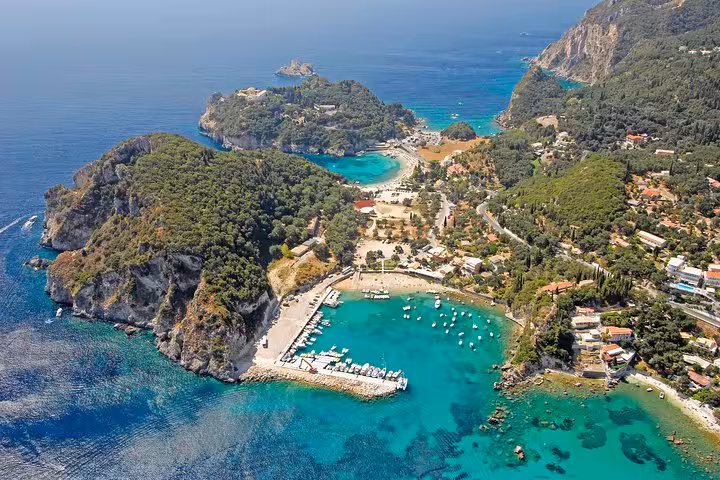 Aerial view of Paleokastritsa, Corfu with emerald coves and marina, highlight of a private Corfu tour