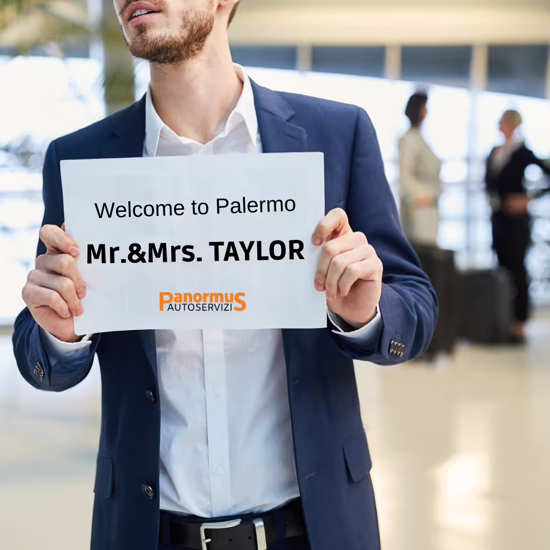 Chauffeur in Palermo airport arrivals hall holding welcome sign for private transfer service to Agrigento accommodation
