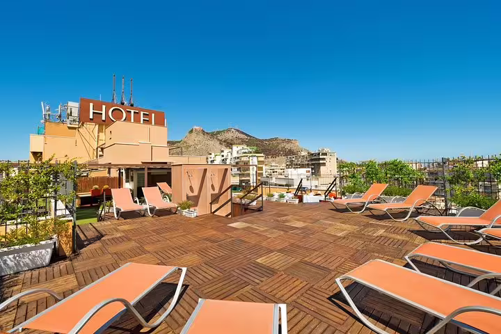 Sunny rooftop terrace of Astoria Palace Hotel Palermo with loungers and city views, ideal after private airport transfer
