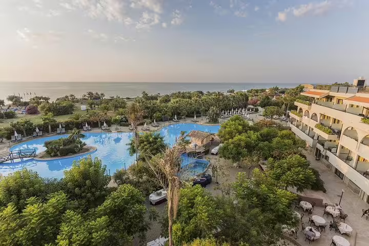 Seaside resort in Campofelice di Roccella with lagoon-style pool and gardens, reached by private transfer from Palermo airport