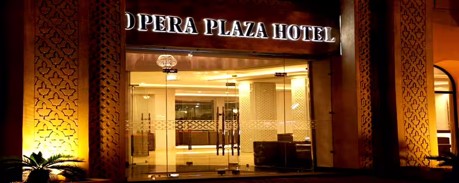 Illuminated entrance of Opera Plaza Hotel at night, welcoming guests arriving by private transfer from Palermo Airport