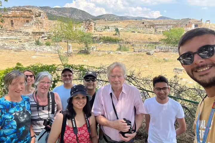 Enthusiastic tourists explore historic ruins in Pamukkale on a guided small group tour from Izmir.