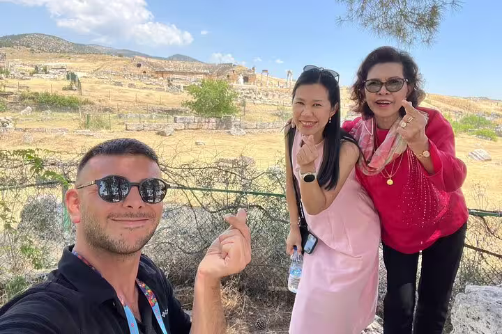Happy tourists enjoying a sunny day at Pamukkale's ancient ruins in Turkey.