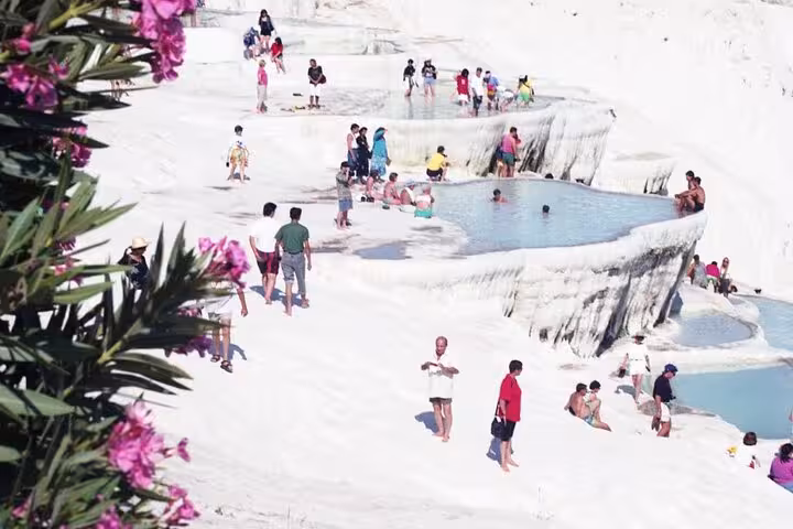 Visitors wade in Pamukkale thermal pools on an all-inclusive private guided tour, iconic white travertines in Turkey