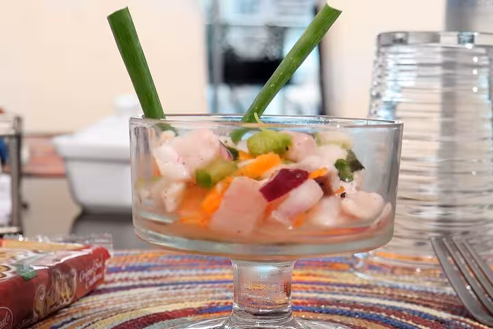 Colorful ceviche with fresh vegetables in a glass dish, garnished with green onions, perfect for a Panamanian cooking class.