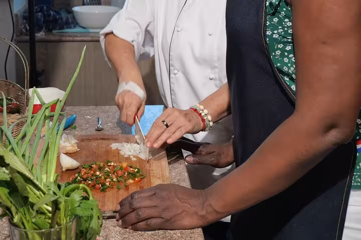 Close-up of chef and participant chopping fresh vegetables in a boozy Panamanian cooking class.