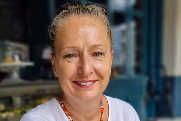 Smiling woman ready to guide you through a boozy Panamanian cooking class with authentic recipes and cocktails.