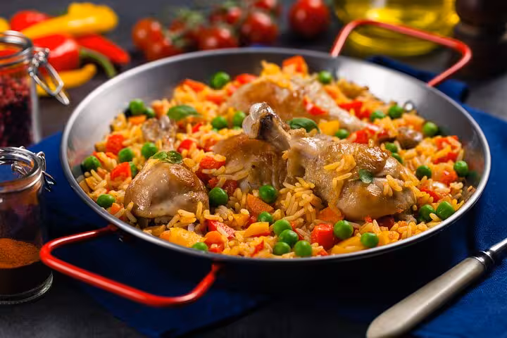 Colorful Panamanian rice dish with chicken, peas, and peppers in a traditional cooking class setting.