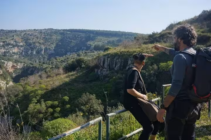 Tourists enjoying panoramic views of Pantalica's stunning landscape on a guided adventure hike in Sicily.