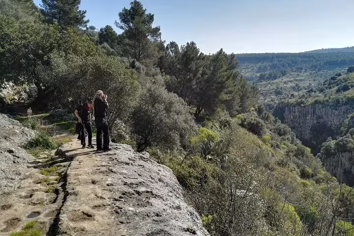 Hikers enjoy panoramic views of Pantalica's lush landscapes on a scenic trail in Sicily's UNESCO World Heritage site.