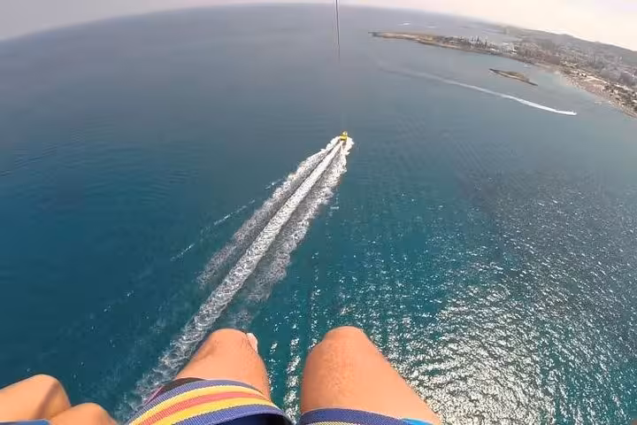 Aerial view parasailing over Red Sea near Hurghada, boat tow trail toward coast, Sahl Hasheesh tour