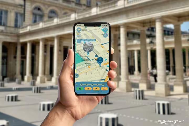 Visitor navigating Paris fashion history tour app at Palais-Royal courtyard with interactive smartphone map guide