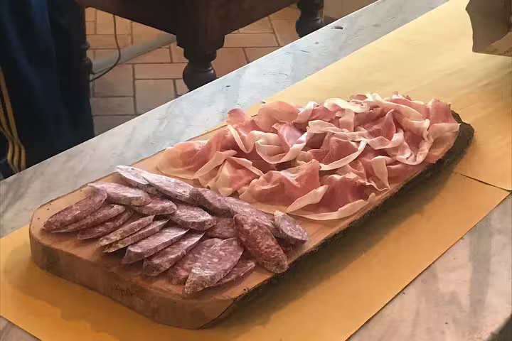 Sliced Parma ham and salami artfully arranged on a wooden board, perfect for an authentic Italian tasting experience.