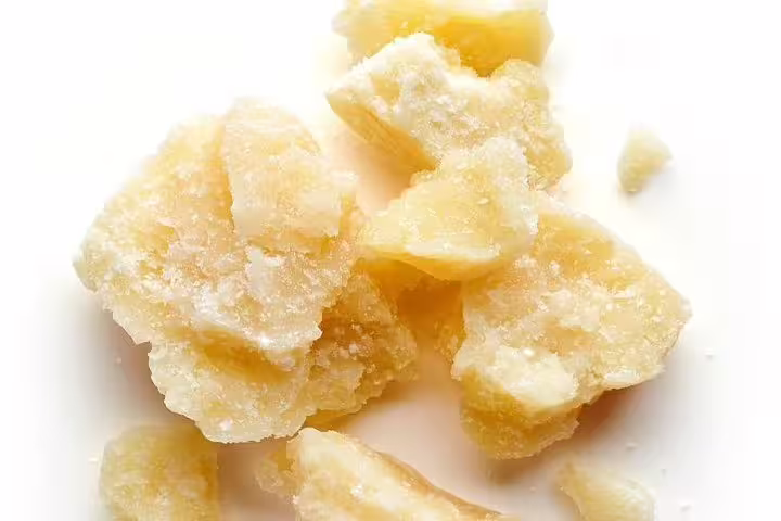 Chunks of aged Parmigiano-Reggiano cheese highlighting its granular texture for the Parmigiano-Reggiano and Parma Ham Tour.