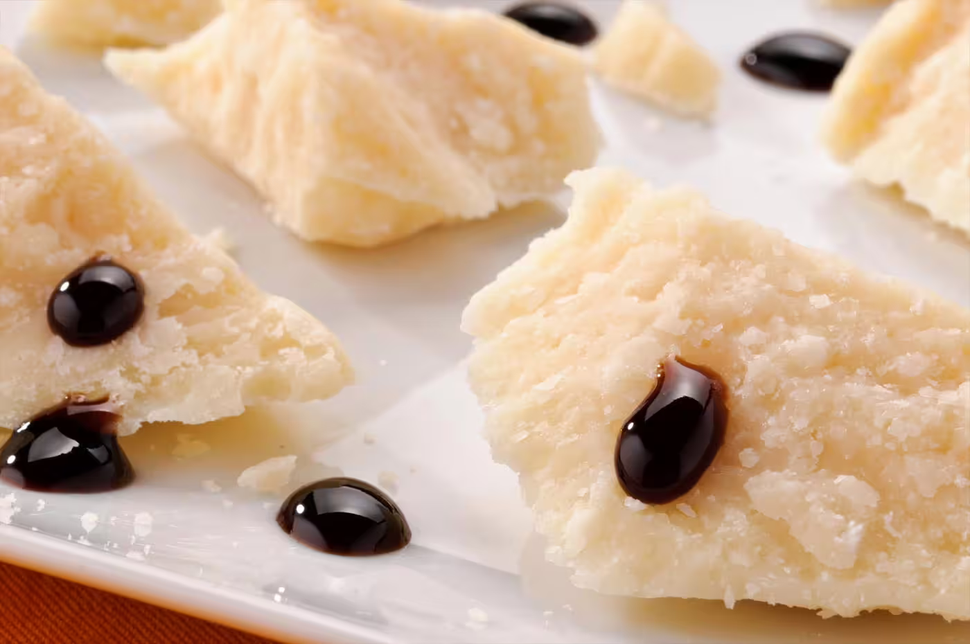 Parmigiano Reggiano shards topped with traditional balsamic vinegar during Modena tasting with aperitif