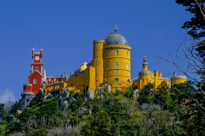 Vibrant view of Pena Palace in Sintra, Portugal, showcasing its colorful architecture on a private tour from Lisbon with monument tickets.