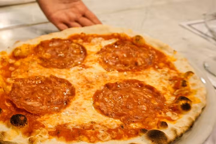Freshly baked pepperoni pizza from a Rome cooking class near Piazza Navona, showcasing authentic Italian flavors.