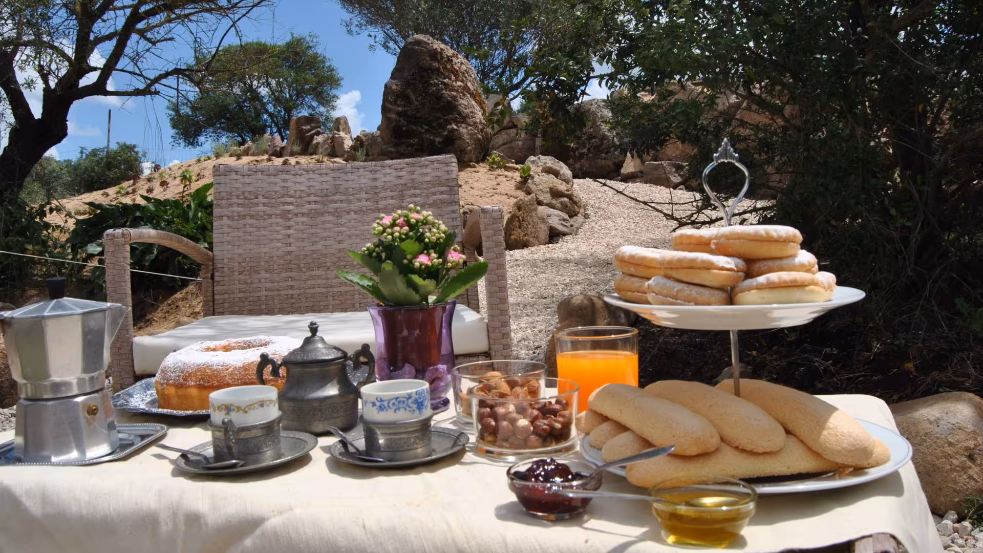 Delightful breakfast spread with pastries, coffee, and juice in a scenic outdoor setting at Perfugas glamping.