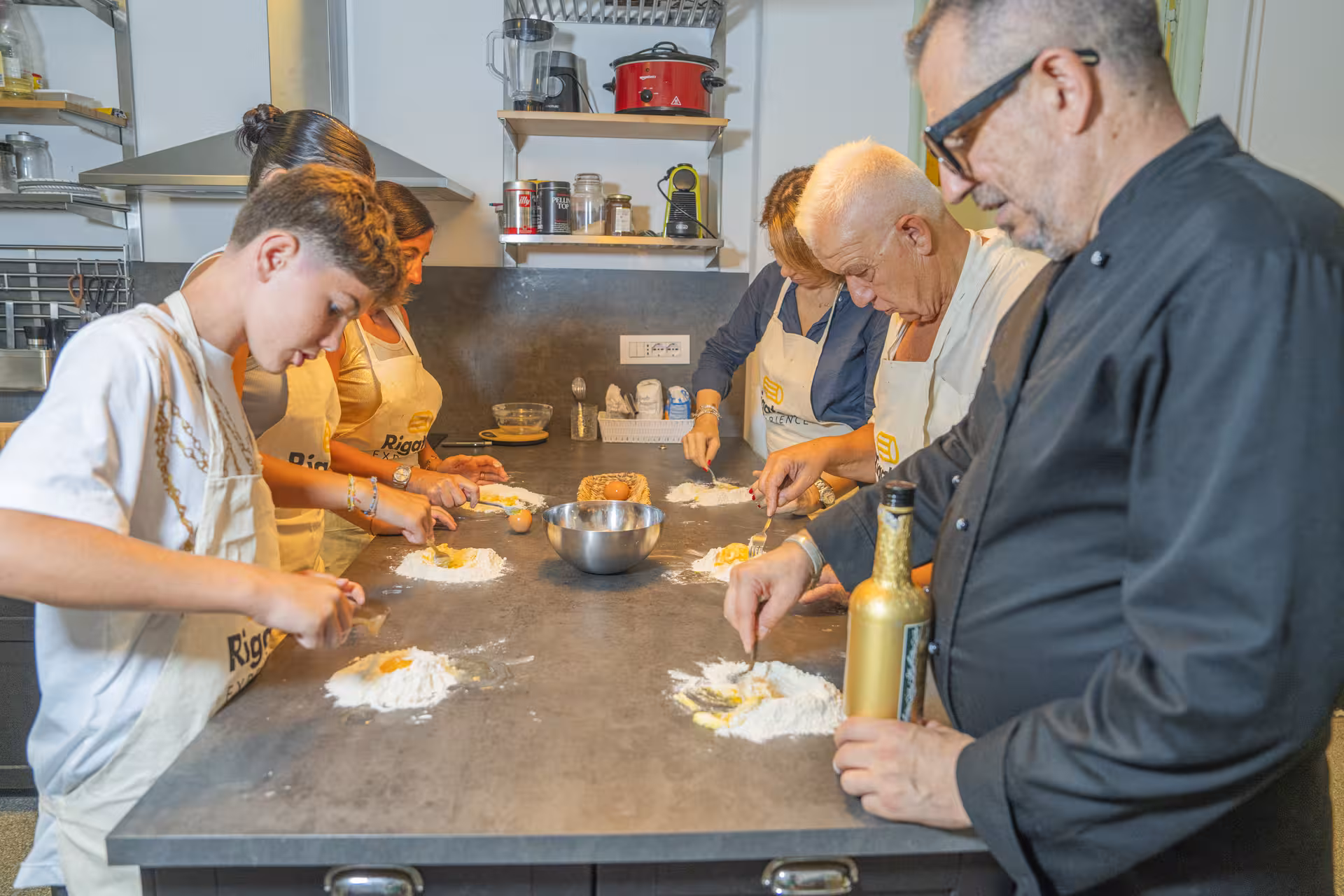 Group of people engaging in pasta-making during a cooking class on the Portofino and Cinque Terre pesto experience.