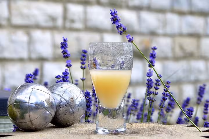 Pastis aperitif beside pétanque boules and lavender, highlighting a Marseille pétanque tour with local flavors