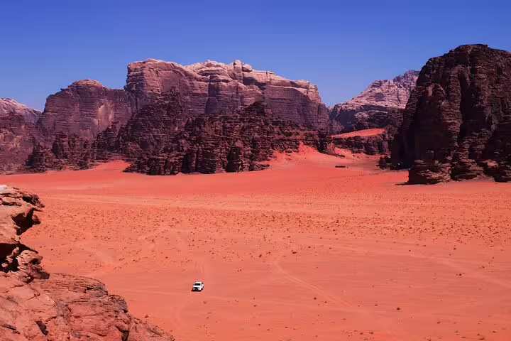 Red sand and towering cliffs in Wadi Rum, scenic drive on Petra tour from Taba by ferry boat to Jordan