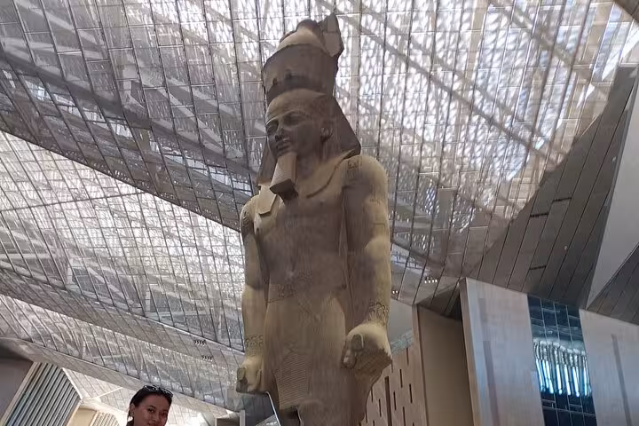 Colossal pharaoh statue inside the Grand Egyptian Museum atrium on a private Cairo museum tour