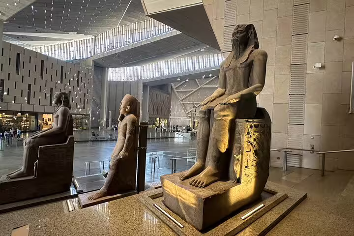 Seated pharaoh statues inside the Grand Egyptian Museum atrium, featured on a private Giza Pyramids day tour