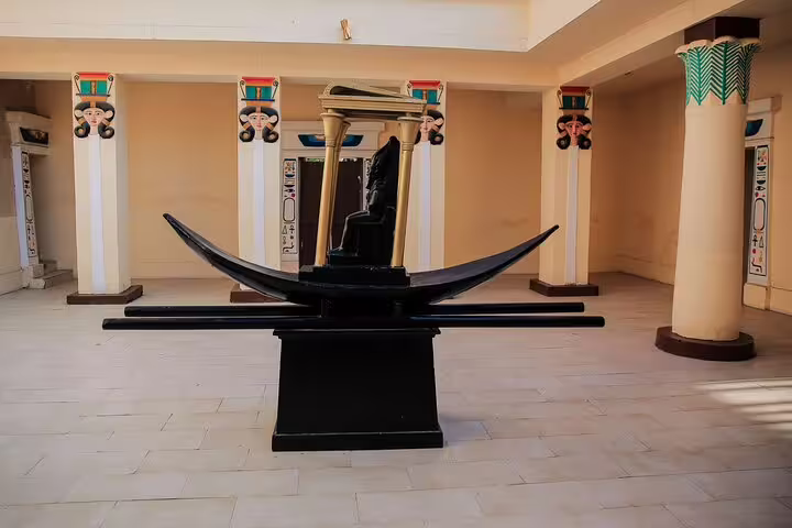 Ceremonial solar boat display in an Egyptian-style hall at Pharaonic Village, Cairo private tour experience