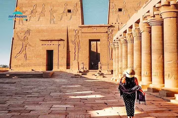 Visitor walking through Philae Temple columns in Luxor itinerary, 2-day Cairo and Luxor tour from Hurghada