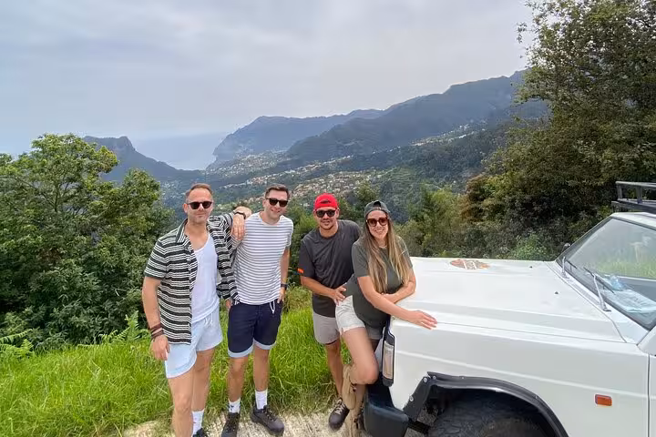 Guests pose by 4x4 jeep at Madeira viewpoint on Pico do Areeiro to Ponta São Lourenço east tour