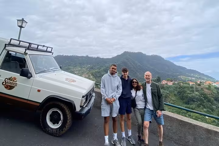 Guests pose by a 4x4 jeep at a Madeira viewpoint on the Pico do Areeiro to Ponta São Lourenço tour