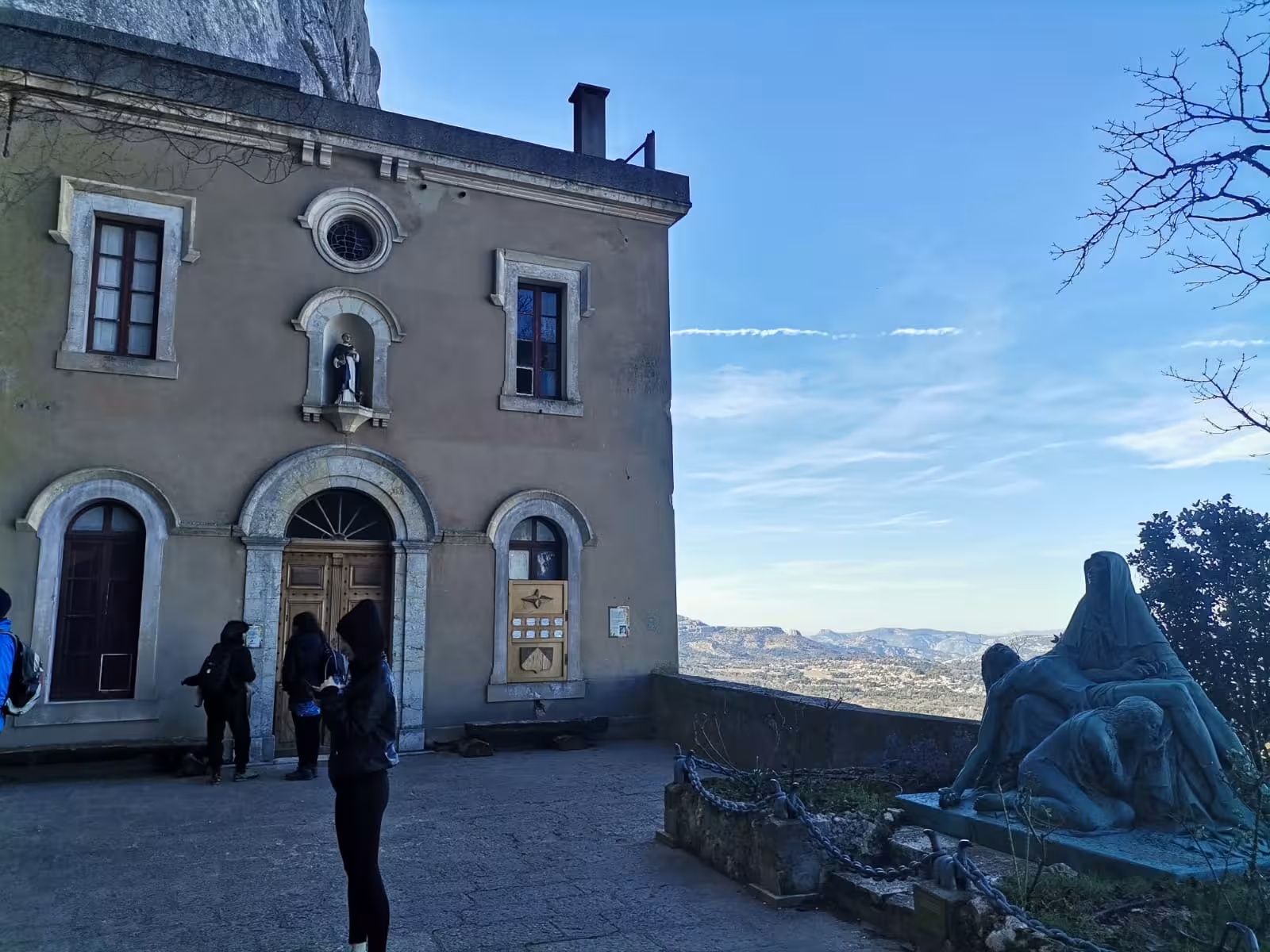 Pilgrims outside Sainte-Baume sanctuary near Grotte Sainte-Madeleine, sacred hike with panoramic views