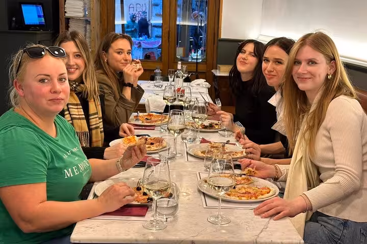 Chef engaging with guests at a pizza cooking class near Piazza Navona, Rome.