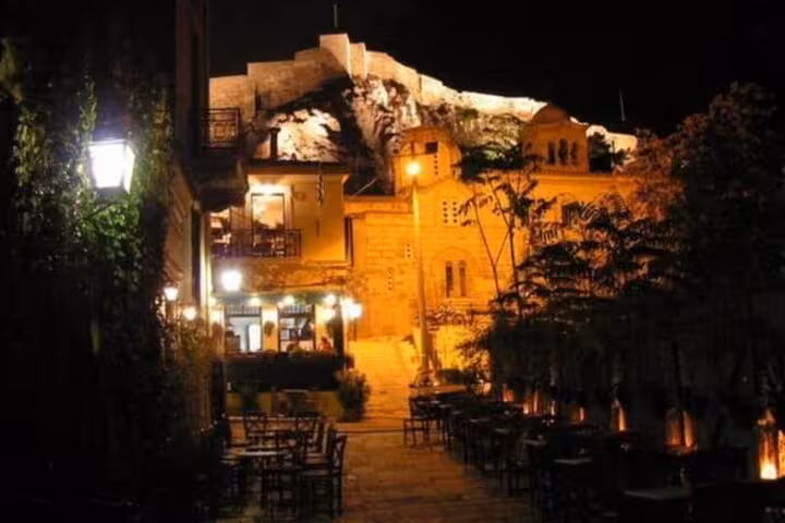 Plaka alley at night with glowing lanterns and Acropolis view, Athens by Night walking tour highlight