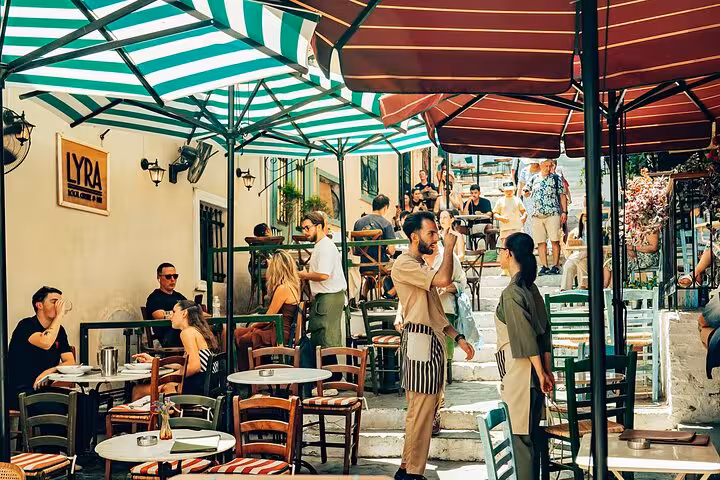 Plaka Athens taverna street with outdoor tables and umbrellas, stop on small-group panoramic city tour