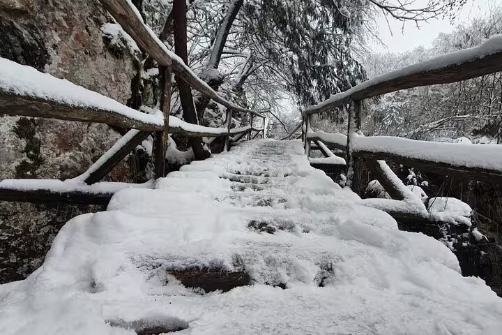 Snowy wooden trail steps at Plitvice Lakes National Park, part of secured tickets tour with train and boat ride