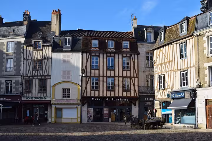 Charming half-timbered buildings in a Poitiers square, highlighting the city's historic architecture on a sunny day.