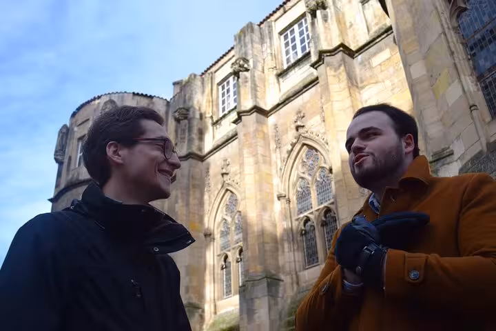 Two people engaging in conversation in front of a historic building during a Poitiers walking tour.