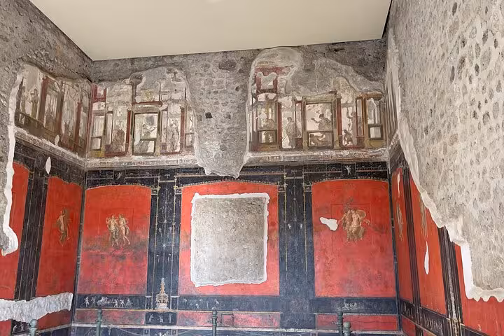 Explore ancient frescoes in a preserved room on a guided small group Pompeii tour from Positano.