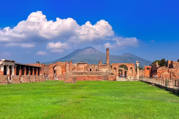 Panoramic view of Pompeii forum ruins and Mount Vesuvius under blue skies on a personalized private archeology tour
