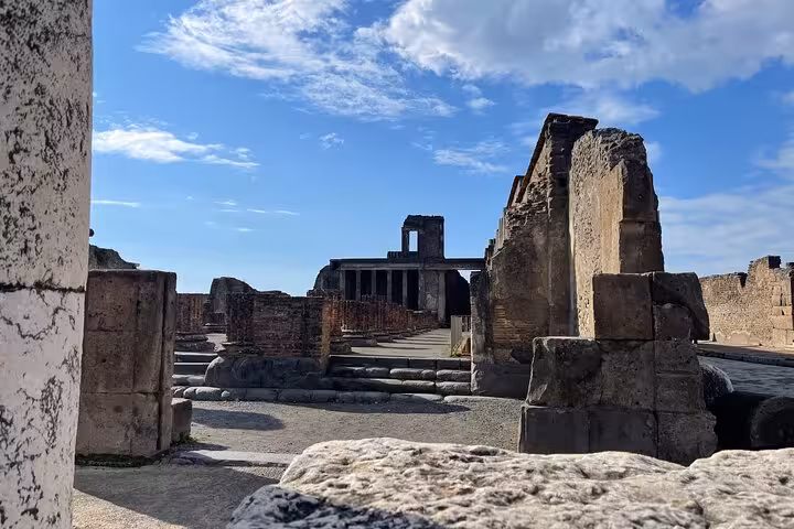 Explore ancient Pompeii ruins under a bright sky on the guided tour from Positano with wine tasting.