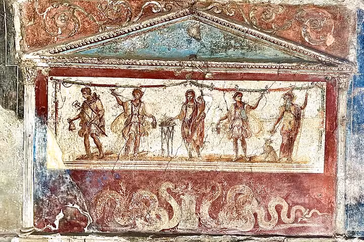 Ancient Pompeii fresco depicting Roman figures, showcasing vibrant art on the Pompeii Guided Tour from Naples.